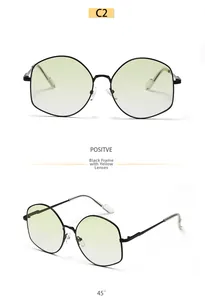 Detail view of oversized polygonal metal frame sunglasses with yellow tinted lenses