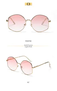 Macro shot of gold-framed polygonal sunglasses with elegant pink gradient lenses
