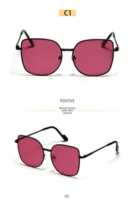 Detailed macro view of black metal cat-eye sunglasses with gradient red lenses and texture