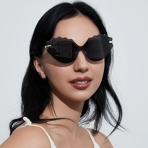 Stylish cat-eye rimless sunglasses with wavy black lenses and thin gold metal temples