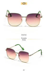 Detail of oversized gold metal sunglasses with purple-pink gradient lenses and cat-eye frames