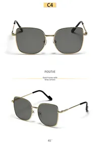 Detail of oversized gold metal cat-eye frame with spiral texture and dark gray lenses