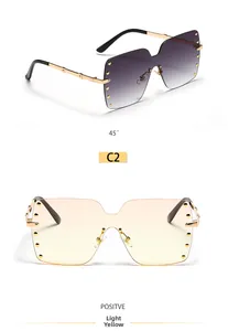 Macro view of rimless square sunglasses featuring gold rivet studs and metallic temples