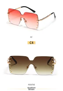 Macro detail of oversized rimless square sunglasses with gold rivet accents and gradient lenses