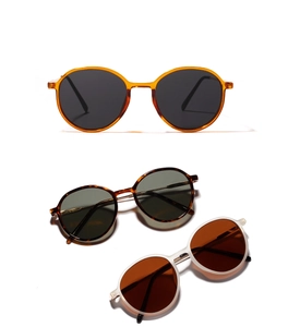 Detailed overhead view of vintage round sunglasses in amber, tortoiseshell, and white matte