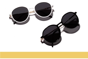 Close-up of retro round sunglasses with black and white frames and gold metal hinges