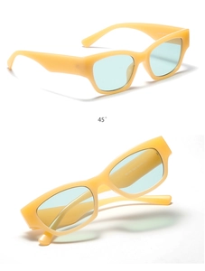 Dettaglio occhiali da sole rettangolari color crema con lenti azzurre e cerniere
