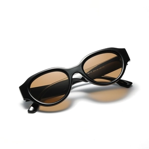 Retro oval cat eye sunglasses with black wide frame and amber tinted lenses for women and men