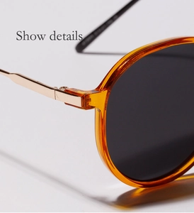 Close-up of golden metal hinge and amber tortoiseshell frame on round sunglasses