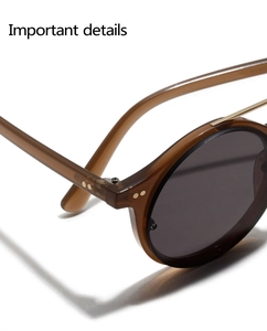 Macro view of retro round amber sunglasses showing reinforced hinges and gold rivets