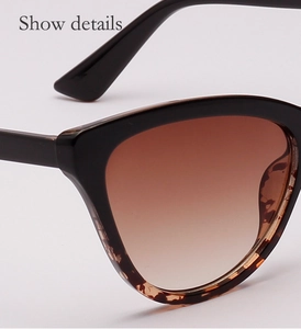 Close-up of cat-eye sunglasses featuring brown gradient lenses and tortoise shell patterns