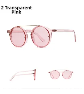 Detail view of retro pink round sunglasses with double gold metal bridge and transparent frame