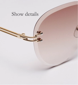 Macro detail of gold metal temples and double rivet hinges on frameless sunglasses