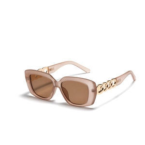 Detail der rosafarbenen eckigen Sonnenbrille mit goldener Metallkette an den Bügeln