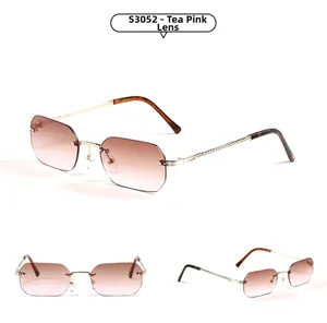Detail view of rimless gradient tea-pink lenses with golden twisted metal frame sunglasses