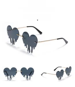 Macro detail of rimless dripping heart sunglasses with grey lenses and gold metal temples