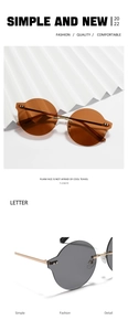 Détail de lunettes de soleil rondes sans monture avec bords ondulés et branches dorées