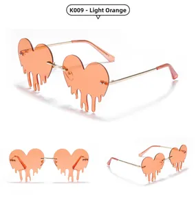 Detail of light orange heart-shaped melting effect sunglasses with gold metal frames