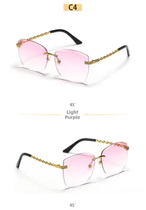 Detail view of pink gradient lenses and gold chain-link metal temples on rimless sunglasses