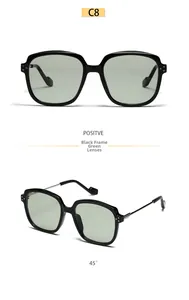 Detail view of square black sunglasses with green lenses and slim metal temples