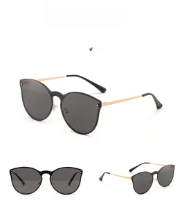 Detail view of rimless cat-eye sunglasses with dark grey lenses and rivet metal temples