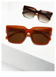 Detail view of square oversized sunglasses with metal rivets on geometric pedestals