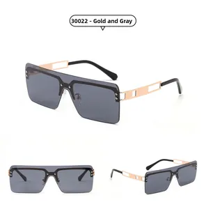Detail view of gold metal hollow temples and oversized gray square rimless sunglasses