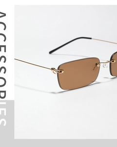 Détail de lunettes de soleil sans monture à verres bruns et branches dorées fines
