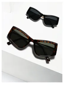 Macro shot of stylish black and tortoiseshell cat-eye sunglasses on a white platform