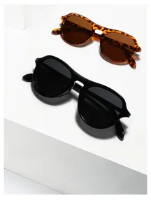Classic black and tortoiseshell oversized sunglasses displayed on a minimalist background