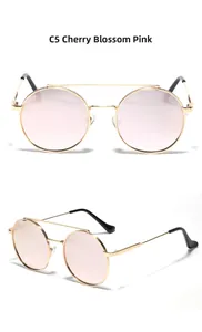 Detail view of Sakura Pink gradient lenses and double-bridge golden metal sunglasses