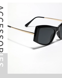 Detail of black oversized cat eye frames with slim gold metal temples and hinge