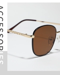Close-up of golden metal sunglasses frame with brown lenses and detailed hinge design