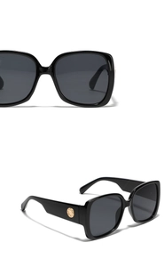 Vue macro de lunettes de soleil carrées noires avec rivets dorés et verres foncés