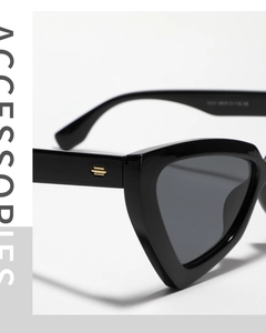 Detail of black cat-eye sunglasses featuring golden step-shaped metal temple accents