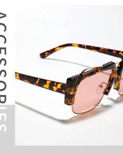 Détail de lunettes de soleil en écaille avec verres roses et monture en métal doré