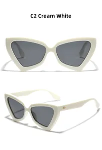 Detail view of creamy white cat-eye sunglasses with gold accents and dark lenses
