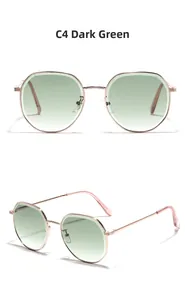 Détail de lunettes de soleil en métal or rose avec verres dégradés vert foncé