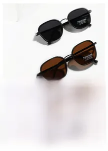 Close-up of TR90 polarized sunglasses with UV400 stickers on minimalist white blocks