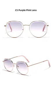 Détail de lunettes de soleil en métal avec verres dégradés violet-rose et monture dorée
