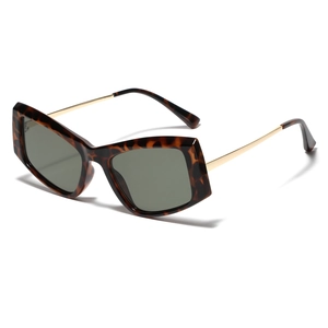 Oversized cat-eye sunglasses with tortoiseshell frames and gold metal temples on white base