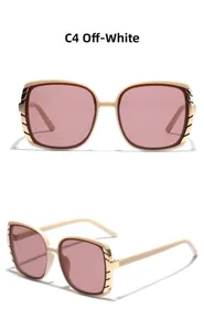 Detail view of square cream sunglasses with purple gradient lenses and gold accents