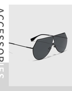 Dettaglio degli occhiali da sole aviator oversize in metallo nero con lente unica