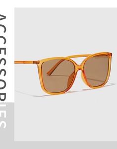 Detail of Y2K orange transparent square sunglasses frame with brown tinted lenses
