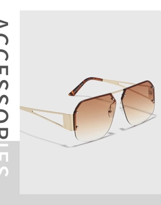 Detail of gold metal temples with geometric hollow cuts and tortoise tips on sunglasses