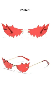 Détail macro de lunettes de soleil rouges sans monture avec branches dorées et verres résine