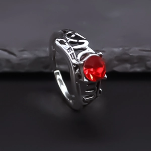Macro side view of vintage silver alloy ring with hollow relief and round red gemstone