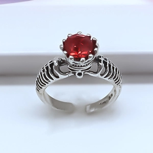 Macro shot of gothic rib skeleton ring with a faceted red ruby stone center