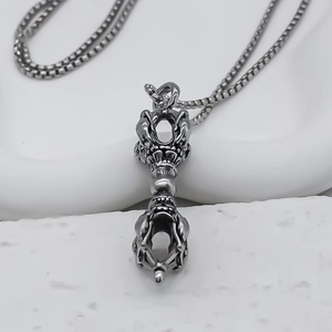 Vue macro du pendentif Vajra en alliage argenté avec relief et chaîne à maillons carrés