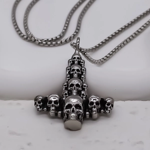 Detailed close-up of dark punk gothic stacked skull cross pendant in stainless steel